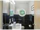 Charming bathroom with a unique circular window, black tile accents, and modern fixtures at 4340 Ashbourne Ln, Indianapolis, IN 46226
