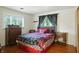 Comfortable bedroom with red and black decor, hardwood floors, and natural light at 4340 Ashbourne Ln, Indianapolis, IN 46226