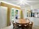 Light-filled dining room featuring a round table, unique light fixture, and French door to backyard at 4340 Ashbourne Ln, Indianapolis, IN 46226