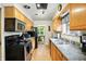 Well-lit kitchen featuring wood cabinets, stainless steel microwave, and view to the dining room at 4340 Ashbourne Ln, Indianapolis, IN 46226