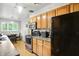 Kitchen with black appliances, oak cabinets and view to the dining area with black table and chairs at 4340 Ashbourne Ln, Indianapolis, IN 46226