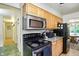 Functional kitchen with wood cabinets, a stainless steel microwave, and views to the dining area at 4340 Ashbourne Ln, Indianapolis, IN 46226