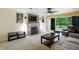 Inviting living room features a stone fireplace, ceiling fan, and a large window with wooded views at 4340 Ashbourne Ln, Indianapolis, IN 46226