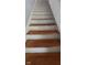 A stairway with worn wood steps and white risers leads to the upper level of the home at 435 N Rural Ne St, Indianapolis, IN 46201