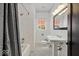 Bathroom featuring tiled floors, a window, a pedestal sink, and a shower/tub at 4356 N College Ave, Indianapolis, IN 46205