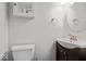 A crisp white bathroom features bronze fixtures and a dark vanity with stylish round mirror at 4356 N College Ave, Indianapolis, IN 46205