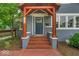 Close up of the home's entrance featuring brick steps, charming pillars, and a stylish front door at 4356 N College Ave, Indianapolis, IN 46205