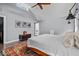 Bright main bedroom with ceiling fan, hardwood floors, skylight, and ensuite bathroom with soaker tub at 4356 N College Ave, Indianapolis, IN 46205