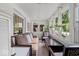 Bright sunroom with multiple windows, comfortable seating, and hanging floral arrangements at 4356 N College Ave, Indianapolis, IN 46205