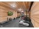 Spacious basement gym with modern equipment and wood paneled walls and ceiling offers at home workouts at 4434 Hickory Ridge Blvd, Greenwood, IN 46143