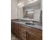 Bathroom featuring a dual sink vanity with dark countertops and wooden cabinets, with a large mirror reflecting the shower at 4434 Hickory Ridge Blvd, Greenwood, IN 46143