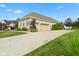 A brick home showcasing a three-car garage and a long driveway lined with manicured landscaping at 4434 Hickory Ridge Blvd, Greenwood, IN 46143