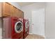 Laundry room featuring a red washer and dryer set with ample cabinet space and a white door at 4434 Hickory Ridge Blvd, Greenwood, IN 46143