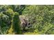 Aerial view of a stone and brick house surrounded by a canopy of mature trees on a lush green lawn at 4446 Lakeridge Dr, Indianapolis, IN 46234