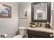 Elegant powder room featuring granite counters, framed mirror, and classic fixtures at 4446 Lakeridge Dr, Indianapolis, IN 46234