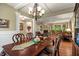 Elegant dining room featuring hardwood floors, decorative chandelier, and seamless flow into living spaces at 4446 Lakeridge Dr, Indianapolis, IN 46234