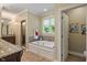 This opulent bathroom features a soaker tub, glass-enclosed shower, and large windows for natural light at 4446 Lakeridge Dr, Indianapolis, IN 46234