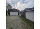 Property featuring multiple garages, each equipped with roll-up doors, set against a gravel ground at 509 S E St, Arcadia, IN 46030