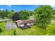 Aerial view showcasing the backyard, wooden deck, detached garage, and mature trees surrounding the property at 5550 W Mooresville Rd Byp, Indianapolis, IN 46221