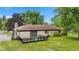 Lush backyard featuring a stone facade home, wooden deck, and mature trees at 5550 W Mooresville Rd Byp, Indianapolis, IN 46221
