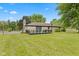 Large, well-maintained backyard featuring lush lawn, stone exterior, and a deck at 5550 W Mooresville Rd Byp, Indianapolis, IN 46221