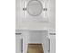 Modern bathroom vanity with white countertop, dark hardware, and stylish circular mirror at 5550 W Mooresville Rd Byp, Indianapolis, IN 46221