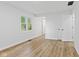 Bright bedroom features light wood flooring, white walls, two closets, and a window with natural outdoor view at 5550 W Mooresville Rd Byp, Indianapolis, IN 46221