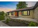 Charming stone home featuring a decorative wood door, landscaped yard, and beautiful exterior lighting at 5550 W Mooresville Rd Byp, Indianapolis, IN 46221
