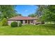 Landscaped front yard featuring the stone exterior of the home and a beautiful lawn at 5550 W Mooresville Rd Byp, Indianapolis, IN 46221