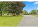 Spacious front yard highlighting the stone facade home, long driveway, and mature trees at 5550 W Mooresville Rd Byp, Indianapolis, IN 46221