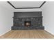 Close up of a stone fireplace with mantel and hearth against white walls and wood-look floors at 5550 W Mooresville Rd Byp, Indianapolis, IN 46221