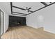 Spacious living room features a stone fireplace, coffered ceiling, wood floors, and access to backyard at 5550 W Mooresville Rd Byp, Indianapolis, IN 46221