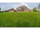 Expansive backyard showcasing lush green lawn and the home's exterior with brick and grey siding at 5706 Bentbrook Dr, Bargersville, IN 46106