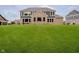 Spacious backyard featuring a well-maintained lawn and the rear exterior of a brick and gray home at 5706 Bentbrook Dr, Bargersville, IN 46106