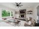 Cozy living room with a stone fireplace, hardwood floors, a ceiling fan, and lots of natural light at 5706 Bentbrook Dr, Bargersville, IN 46106