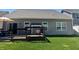 Wooden deck with outdoor dining set, gray house siding, and a well-maintained lawn at 5932 Edelle Dr, Indianapolis, IN 46237