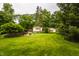 Spacious backyard featuring a well-maintained lawn and mature trees, showcasing the home's exterior at 6295 N Olney St, Indianapolis, IN 46220