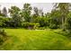 Expansive lawn with mature trees and landscaping creates a picturesque and serene backyard setting at 6295 N Olney St, Indianapolis, IN 46220
