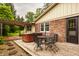 Outdoor patio features a hot tub and outdoor dining set, nestled in a lush backyard setting at 6295 N Olney St, Indianapolis, IN 46220