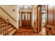 The foyer boasts hardwood floors, wooden staircase and a front door with glass panels at 6295 N Olney St, Indianapolis, IN 46220