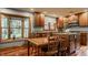 Eat-in kitchen features blue walls, wood cabinetry, stainless steel appliances and a window overlooking the yard at 6295 N Olney St, Indianapolis, IN 46220