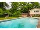 Large in-ground pool with mature trees and lush landscaping provides a tranquil backyard setting at 6295 N Olney St, Indianapolis, IN 46220