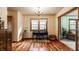 Inviting sitting room features natural light, piano, wood floors, and stylish decor at 6295 N Olney St, Indianapolis, IN 46220