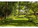 Manicured lawn with lush flowerbeds, mature trees, and a winding walkway leading to the brick and siding home at 6295 N Olney St, Indianapolis, IN 46220