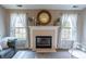 Charming fireplace with mantle, flanked by windows with decorative decor and soft lighting at 63 Longfellow Ln, Greenfield, IN 46140
