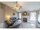 Bright living room with a fireplace, ceiling fan, neutral color palette, and lots of natural light at 63 Longfellow Ln, Greenfield, IN 46140