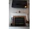 Living area fireplace with brown tile surround and black metal screen, topped by decor and a mounted flatscreen at 6524 Amick Way, Indianapolis, IN 46268