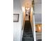 Carpeted staircase leading upstairs, featuring a hanging light fixture and wall art at 6524 Amick Way, Indianapolis, IN 46268