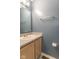 Half bathroom with gray walls, wood cabinets, mirror, and chrome fixtures at 6937 Thousand Oaks Dr, Indianapolis, IN 46214