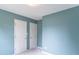 Neutral bedroom features two white doors, light gray carpet, and soft blue paint at 6937 Thousand Oaks Dr, Indianapolis, IN 46214